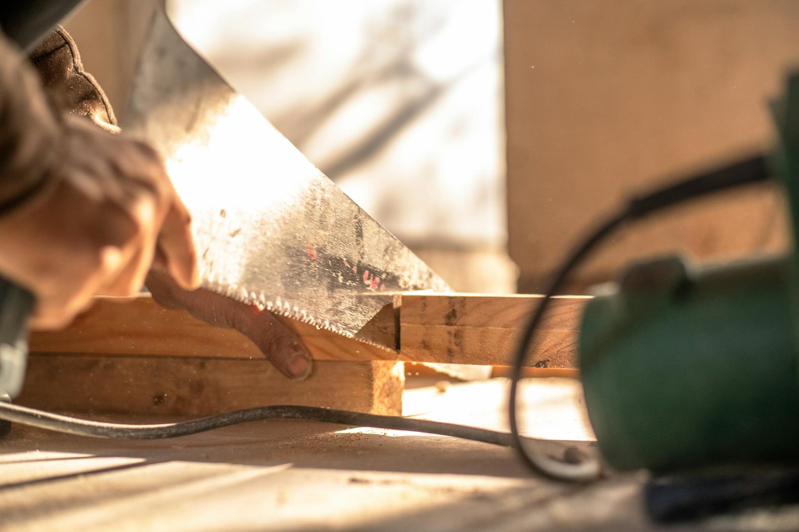 Carpenter cutting wood with a hand saw, showcasing craftsmanship and precision.